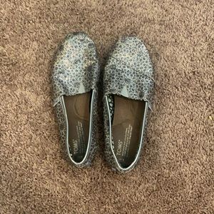 Tom’s silver and black shoes